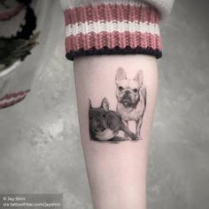 a small dog and cat tattoo on the left calf's leg, which is sitting next to each other