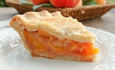 a piece of pie sitting on top of a white plate next to an apple basket