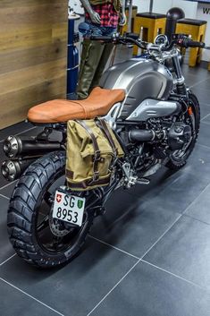 a motorcycle parked in a garage next to a man with a backpack on it's back