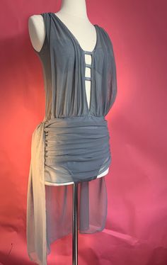 a mannequin wearing a gray top with sheer fabric on the bottom and sides