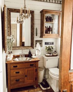 a bathroom with a sink, toilet and mirror in it's corner area next to a doorway