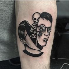 a man's arm with a black and white tattoo on it, depicting two faces