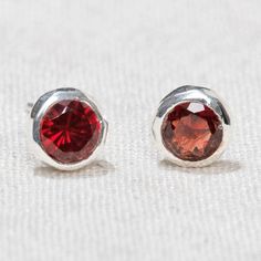 The perfect pomegranate, these Garnet Stud Earrings in sterling silver lend their light, lore, and powerful lilt to all those who want to stand up and shine. It’s amazing that the flash of silver and the subtle dance of light on this enigmatic red stone can have such a positive pleasurable impact. Known for their sensual style, passionate prowess, and guiding light, these garnet studs are glorious. “With these studs, I invoke warmth and light and stoke my inner fire even in the darkest hour” Description Splashed in the sparkle of sterling silver and adorned with the glowy goodness of the Garnet stone, these garnet earrings are every inch as spellbinding as they sound. Garnet is a fabled gem - said to be the only light on Noah's Ark and linked to the ancient Greek myth of Persephone, this g Darkest Hour, Greek Myth, Gold Stud Earrings, Garnet Earrings, Garnet Stone, Gold Stud, Garnet Gemstone, Red Stone, Sterling Silver Studs