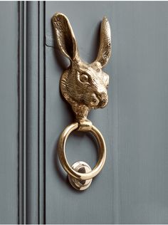 a metal door handle with a rabbit head on it's side and a ring at the end