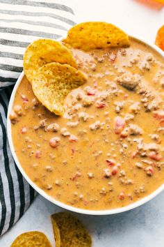 a white bowl filled with beans and tortilla chips on top of a table