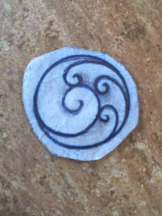 a blue and white stone with the letter e on it sitting on a brown surface