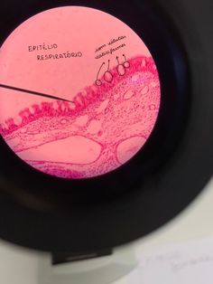 a close up of a pink and black object with writing on the inside of it