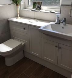 a bathroom with a sink, toilet and window in it's side view area