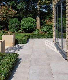 an outdoor patio with stone planters and trees