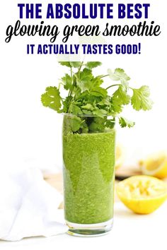 a green smoothie in a glass with cilantro and parsley on the side