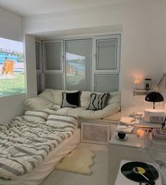 a room with a bed, couch and record player on the wall next to it