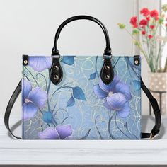 Introducing our Luxurious Light Blue Morning Glory Vegan Leather Tote Bag - an Elegant Floral Handbag designed for the modern woman who appreciates sophistication and style. Key Features: 🌸 Chic Sizing Options: Choose from three sizes - Small, Medium, and Large, ensuring the perfect fit for every woman's lifestyle. 🎨 Customizable Elegance: Elevate your style with two color options for straps, handles, and threads, allowing you to express your unique personality. 🌼 Artistry in Every Detail: Immerse yourself in the breathtaking Luxurious Light Blue Morning Glory print that graces the entirety of this stunning handbag. 👜 Thoughtful Design: Equipped with sturdy top handles that provide both comfort and balance, ensuring your style effortlessly complements your everyday activities. 🌟 Versa Blue Rectangular Shoulder Bag For Office, Blue Rectangular Office Bag, Rectangular Blue Office Bag, Luxury Blue Satchel As Gift, Blue Rectangular Box Bag For Office, Rectangular Blue Box Bag For Office, Blue Leather Box Bag With Handles, Blue Square Shoulder Bag With Detachable Handle, Elegant Blue Square Satchel