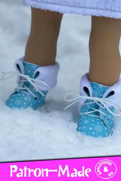 a doll's feet wearing blue shoes in the snow