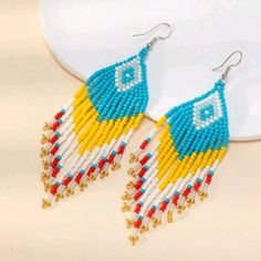 Colorful Beaded Earrings With A Diamond And Chevron Pattern Blue, Red, White, Gray, Yellow, Gold & White 4" Long 1.1" Across E#1300 Tags: Beaded Tribal Boho Bohemian Festival Summer Spring Statement Boho Bar, Minnie Mouse Earrings, Ombre Yarn, Tory Burch Earrings, Spider Earrings, Bottle Earrings, Native Beadwork, Bohemian Festival, Festival Summer