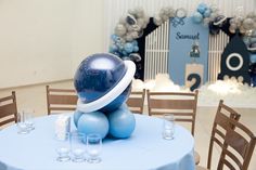 a blue balloon sitting on top of a table with glasses and wine glasses around it