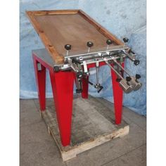 a red foosball table sitting on top of a wooden floor next to a blue wall