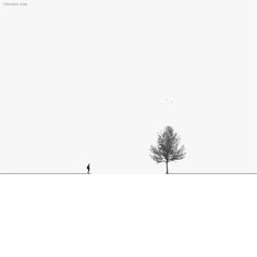 two people are standing in the snow near a tree and one is flying a kite