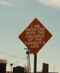 an orange sign that says i am infected with the callings of the cowboy's life