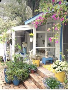 the front porch is decorated with flowers and potted plants