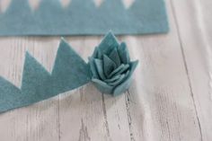 a blue flower sitting on top of a piece of felt next to another piece of fabric