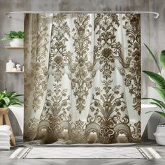 a bathroom with a shower curtain that has an ornate design on it and is next to a potted plant