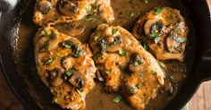 chicken with mushrooms and gravy in a cast iron skillet on a wooden table