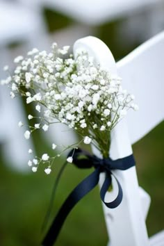 a small bouquet of baby's breath tied to a white cross