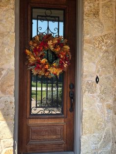 a front door with a wreath on it and a wrought iron fence behind the door