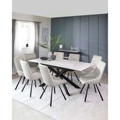 a dining room table with white chairs and a plant