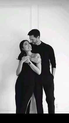 a man and woman embracing each other in black and white