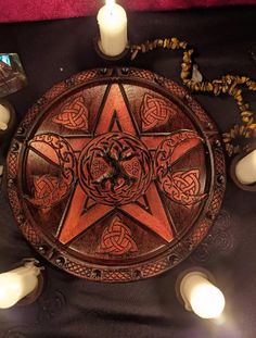 a wooden pentagram surrounded by candles on a table