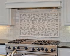 a stove top oven sitting inside of a kitchen next to a wall covered in tile