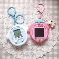 there are two electronic gadgets on the lace doily, one has a keychain and the other has an alarm clock