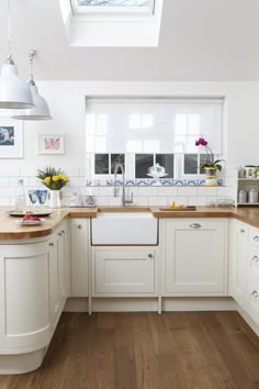 a kitchen with white cabinets and wooden counter tops