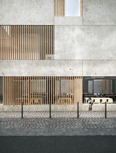 a building with wooden slats on the side and people walking in front of it