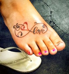 a woman's foot with the word love tattooed on it