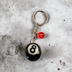 a keychain with a black and white eight - ball charm hanging from it