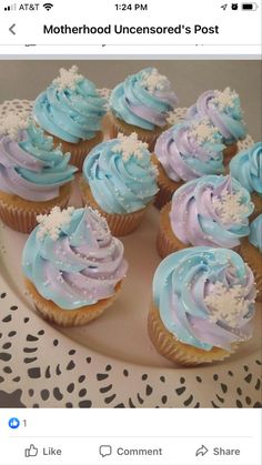 blue and purple cupcakes on a plate with white lace doily around them