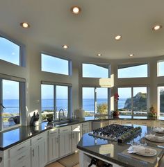 a large kitchen with lots of windows overlooking the ocean