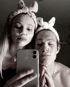 two people with bunny ears on their heads taking a selfie in front of a mirror