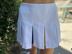 Here is a vintage 1970s white polyester skirt.Made by Billie Jean King.Made out of white polyester fabric.Following is the measurements. Waist 26",hips full, length 13".Zips up the back. One pocket on back side.Has pleats with different colors.In nice vintage condition.Please take special consideration of measurements. 1970s sizing was very small to today's standards. Tennis dresses were very short not like a regular dress. So please take special note of length. If you live overseas please email Retro Fitted White Skirt, White Accordion Pleated Mini Skirt, White Pleated Skirt With Accordion Pleats For Spring, White Bottoms With Accordion Pleats For Summer, White Summer Tennis Skirt With Accordion Pleats, Retro White Skort For Summer, White Retro Skort For Summer, White Accordion Pleats Skirt For Summer, White Accordion Pleated Summer Skirt