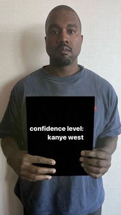 a man holding up a sign that says,'conference level kanny west '