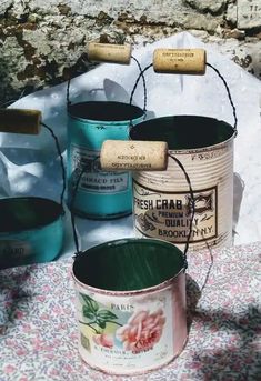 three buckets with labels on them sitting on a table next to some paper towels