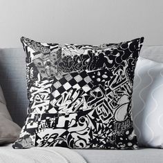 a black and white pillow on a couch with some pillows in front of it,