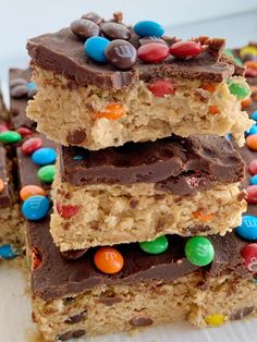 three pieces of cereal bars stacked on top of each other with chocolate and m & ms in the middle