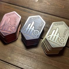 three different types of metal playing cards on a wooden surface with space for text or image