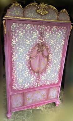 a pink and gold painted cabinet with ornate designs