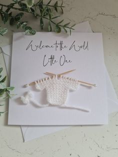 a card with two knitting needles on it and the words welcome to the wool little one