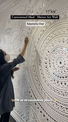 a woman is painting a wall with white paint