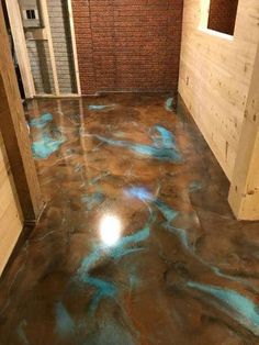 the inside of a building with blue and green paint on the floor in front of it